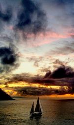 Sailboat in sea against sky during sunset