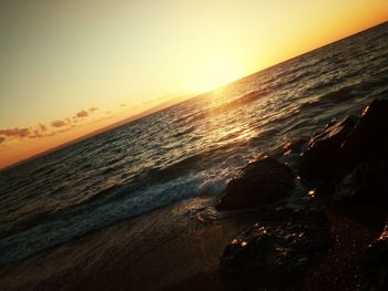 Scenic view of beach against sky during sunset