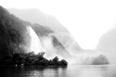 Scenic view of waterfall against sky in milford sound, new zealand
