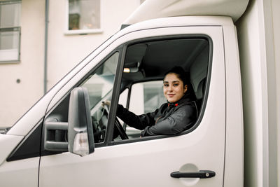 Portrait of young delivery woman driving truck