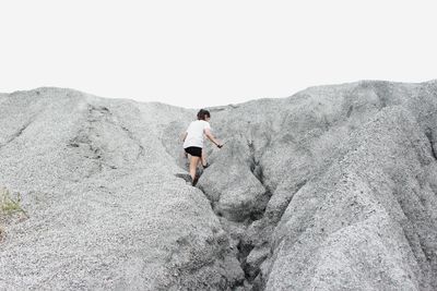 Low angle view of female hiker hiking on rock formation