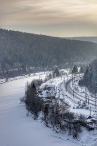 Aerial view of snow covered landscape against sky during sunset