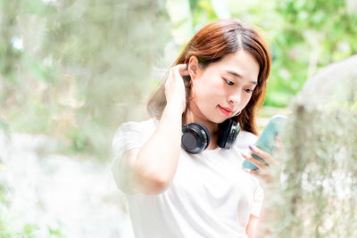 Portrait of young woman using mobile phone outdoors