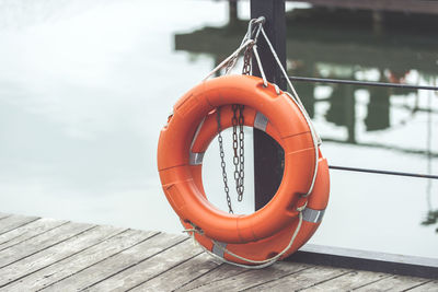 Close-up of life belts hanging on pier over sea