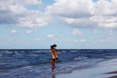 Full length of man walking on beach against sky