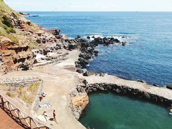 High angle view of rocks on beach against sky