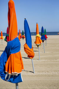 Multi colored umbrellas on beach against clear sky