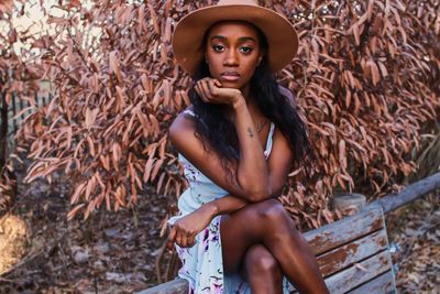 Portrait of young woman looking away while sitting outdoors