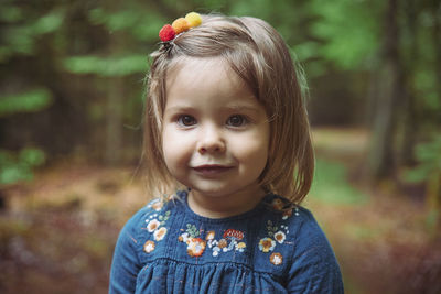 Beautiful baby in an embroidered shirt walks in the forest