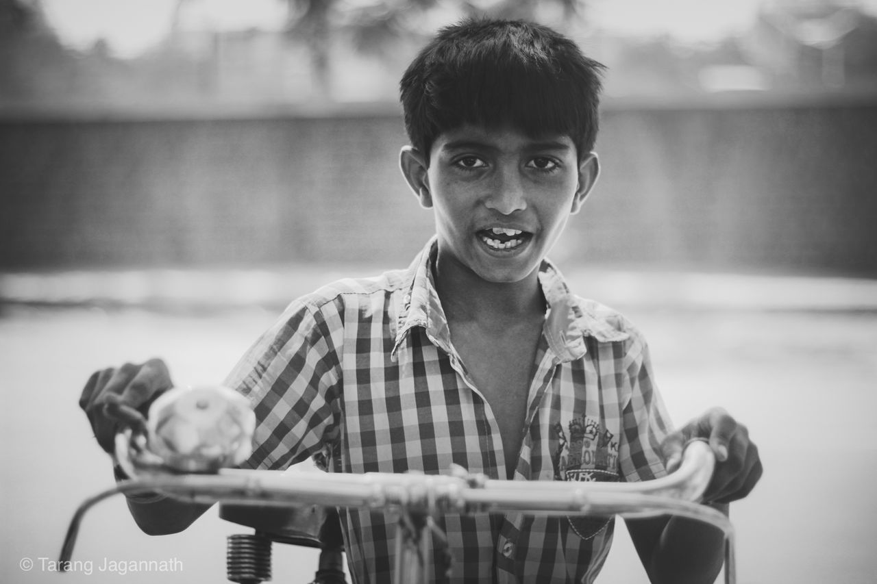 focus on foreground, person, looking at camera, portrait, lifestyles, indoors, casual clothing, leisure activity, front view, food and drink, holding, childhood, boys, elementary age, waist up, smiling, food, standing