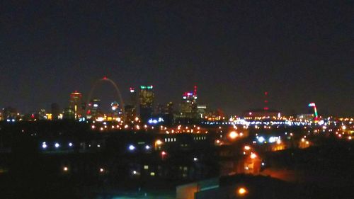 Illuminated cityscape against sky at night