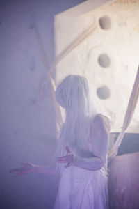 Woman performing by window in abandoned building