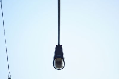 Low angle view of electric hanging against clear sky