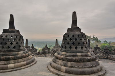 Stupas at temple against sky