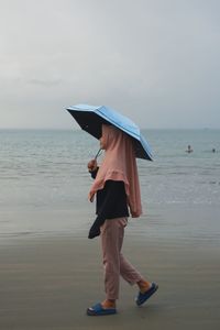 Full length of woman standing on beach