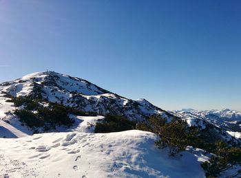 Scenic view of snow covered mountains against clear sky