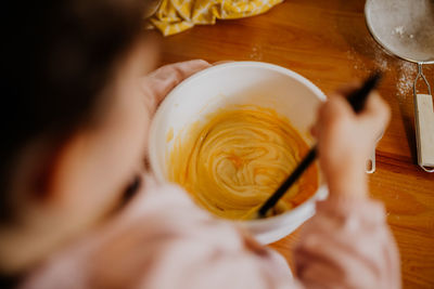 Child mixing ingredients for baking a cake