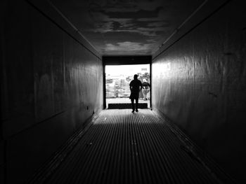 Rear view of man walking in tunnel