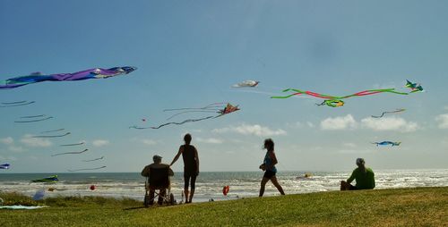 People on beach against sky