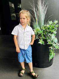 Portrait of young woman standing against plants