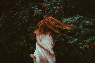 Midsection of woman standing by tree in forest