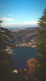 Aerial view of city by sea against sky