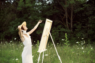 Woman with umbrella standing on field