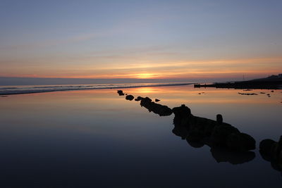 Scenic view of beach against sky during sunset