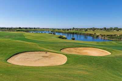 Scenic view of golf course against sky