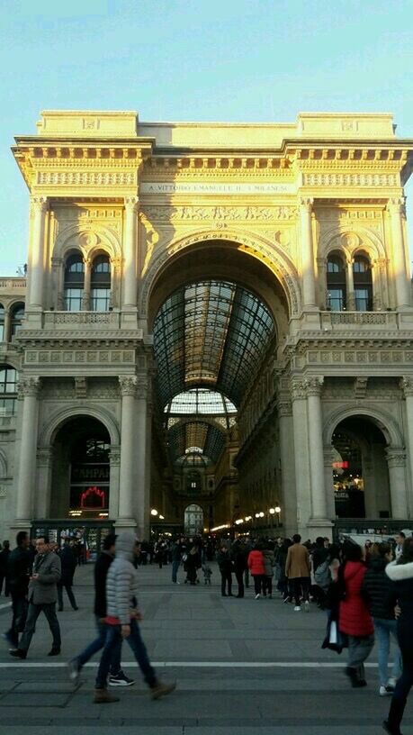 architecture, built structure, building exterior, large group of people, person, men, lifestyles, walking, city life, city, arch, clear sky, leisure activity, facade, tourist, street, travel destinations, travel, sky