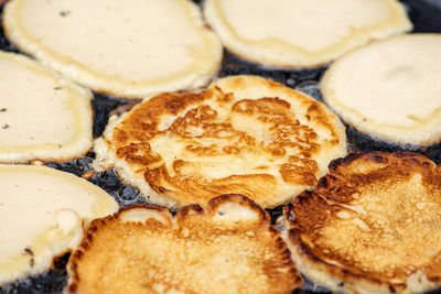 Cooking blini, blin or blynai, pancakes traditional sweet food, preparing outdoor on an open fire