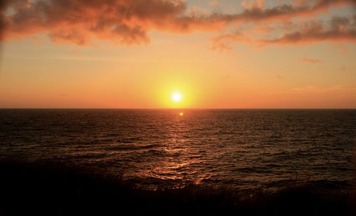 Scenic view of sea against orange sky