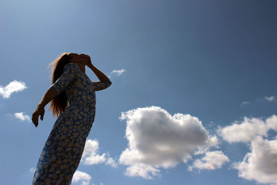 Low angle view of woman standing against sky