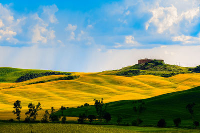 Scenic view of grassy field against cloudy sky