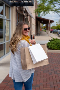 Young woman wearing sunglasses standing on footpath