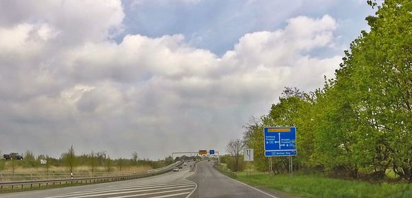 Empty road against cloudy sky