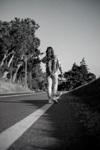 Rear view of woman walking on road