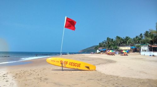 Close-up of flags on beach against clear sky