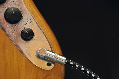 Close-up of guitar against black background