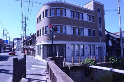 Street amidst buildings against blue sky