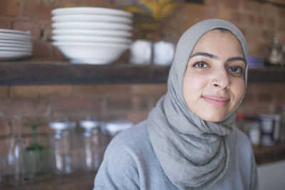 Muslim businesswoman wearing a hijab in her kitchen