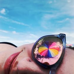 Close-up of person wearing sunglasses against sky