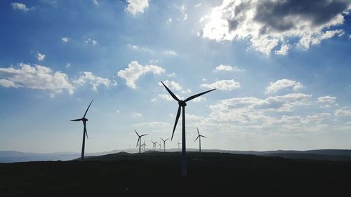 Low angle view of windmills against sky