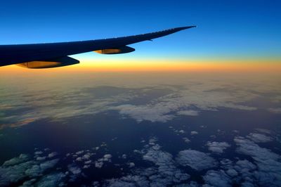 Cropped image of airplane wing over landscape