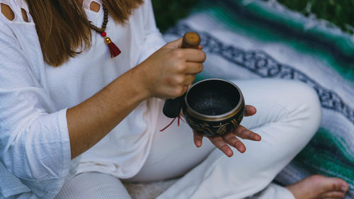 High angle view of woman holding tibetan singing bowl