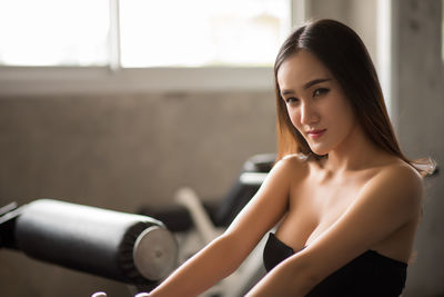 Portrait of young woman exercising in gym