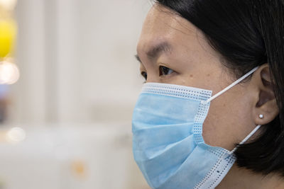Close-up of woman wearing mask looking away
