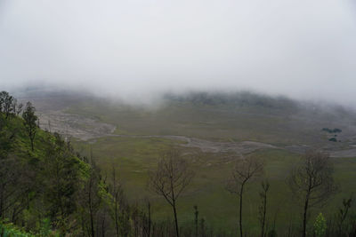 Scenic view of landscape against sky during foggy weather