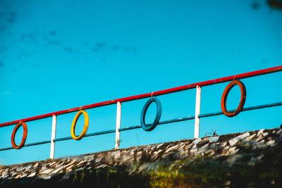 Low angle view of text on railing against sky