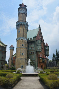 Low angle view of fountain amidst buildings against sky